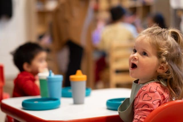 Toddler girl enjoying organic meal at table at Choober Doobers family home daycare in Shoreline WA