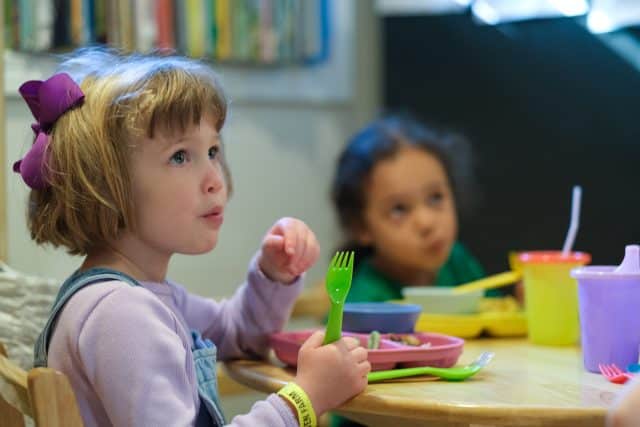 Young girl eating organic meal at table at Choober Doobers family home daycare in Shoreline WA
